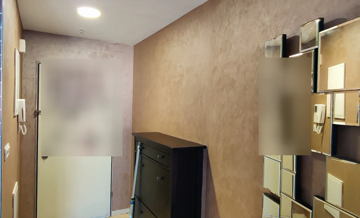 מבואת כניסה אחרי חידוש קיר במרקם מתכתי בגוון ברונזה בהיר לצד מראות