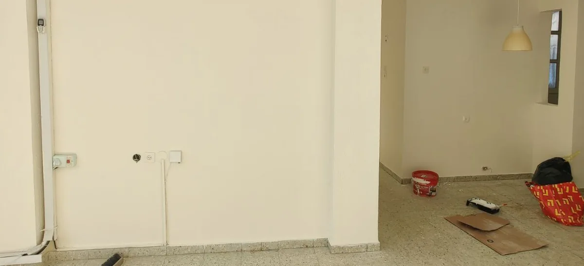 קירות בהירים בסלון לאחר הסרת הסימונים וצביעה