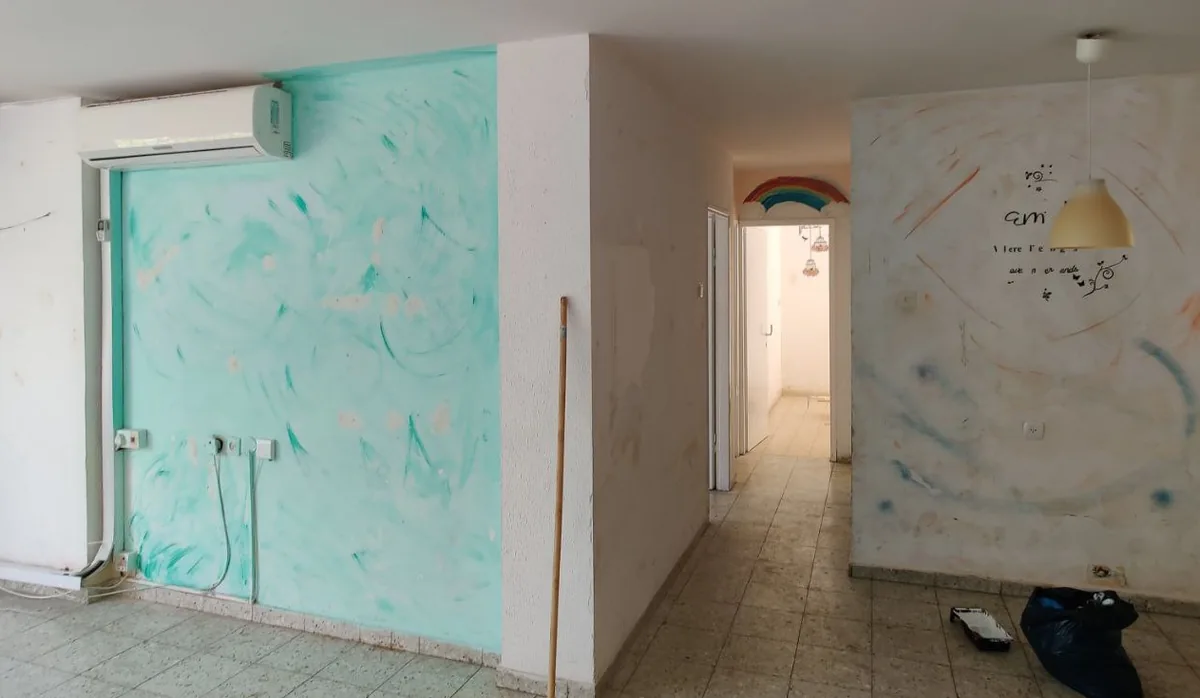 סלון עם ציורים וסימונים על הקירות לפני הצביעה